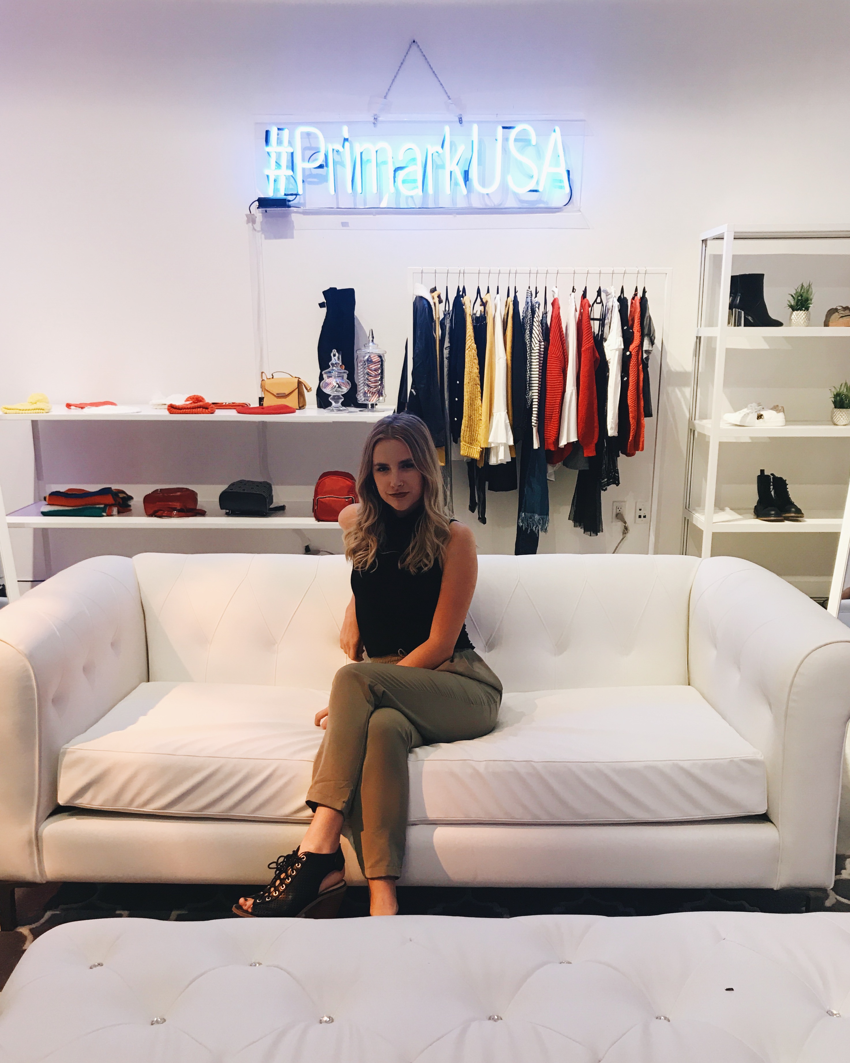 College fashion blogger at Hercampus College Fashion week in New York city sitting in front of a Primark sign and clothing store